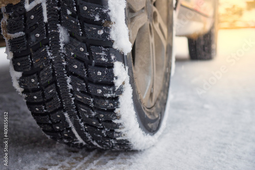 Billede på lærred Winter studded tires on snowy road