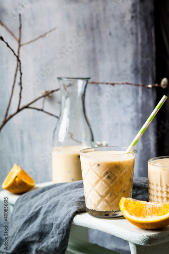Glasses of fresh fruit smoothie with oranges, bananas, yogurt and grenadine