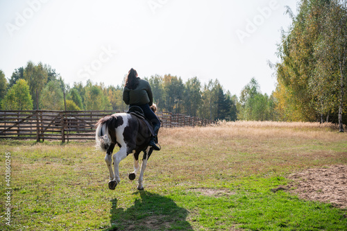 Horse ride of a young girl in places with beautiful autumn countryside landscapes.