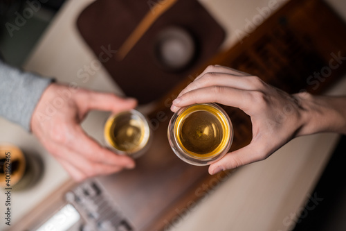 A mysterious tea ceremony for two. Top view  harmony shot with the hands of a man and a girl drinking chinese tea from special bowls