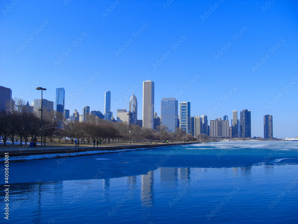 Skyline of Chicago, IL, USA on a cloudless, sunny winter day. Lake Michigan is partly frozen.
