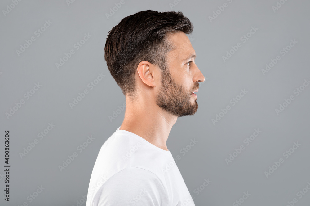 Obraz premium Profile portrait of middle-aged man over grey background