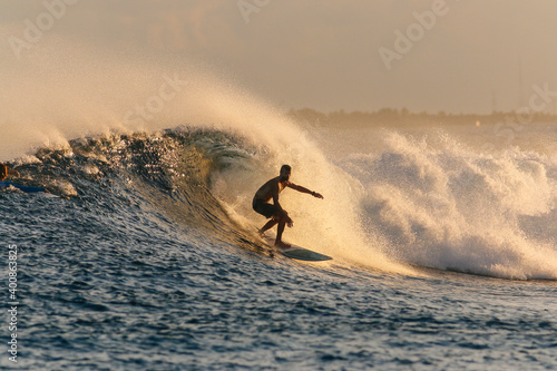 Mid adult man surfing on sea during sunset photo