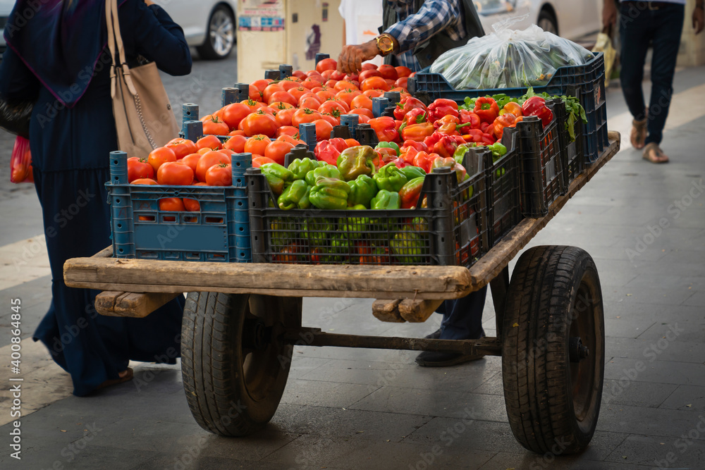 Hand truck selling tomatoes and peppers on the street