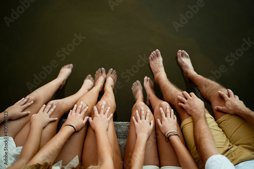 Family dangling legs over lake