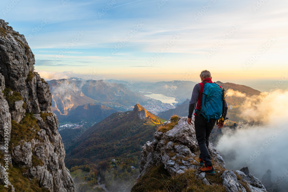 Pensive male hiker walking on mountain peak during sunrise at Bergamasque Alps, Italy Pensive male hiker walking on mountain peak during sunrise at Bergamasque Alps, Italy