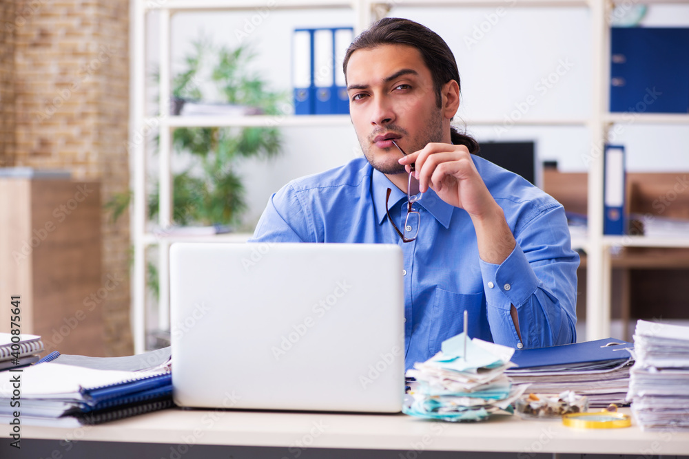 Young male bookkeper in budget planning concept Young male bookkeper in budget planning concept
