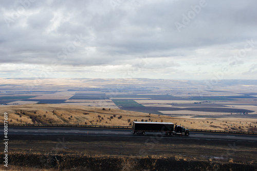 A beautiful autumn landscape, a bird's-eye view of the highway along which the trucks travel. Pendleton, Oregon scenic Highway, Oregon, USA, 12-15-2020