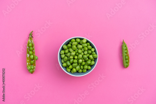 Studio shot of two green pea pods and bowl of green peas photo