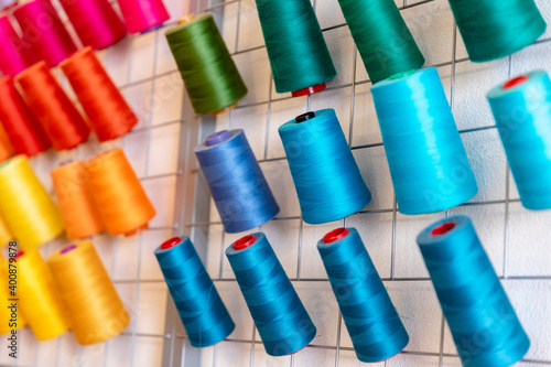 Close-up of colorful thread spools on rack at design studio photo