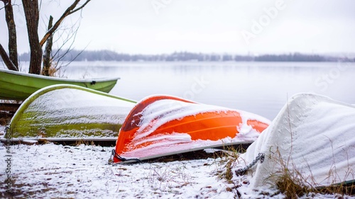 colorful boats covered with light snow