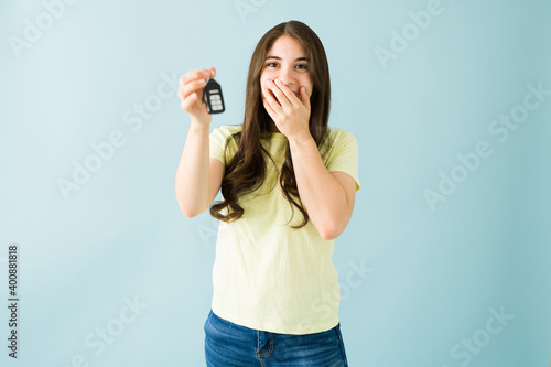 Young woman just received the keys of her brand new car