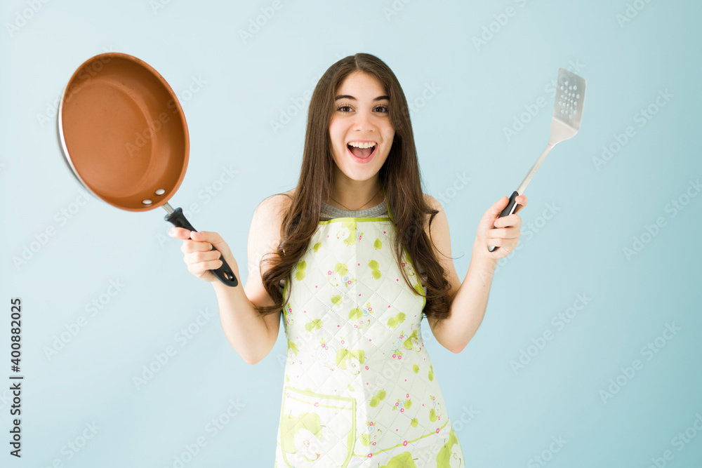 Young woman is excited to cook dinner with her new cookware set