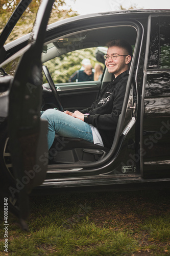 Junger Mann im Auto lachend