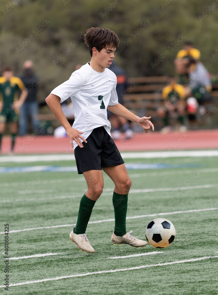 Athletic young boy playing in a competitive soccer game
