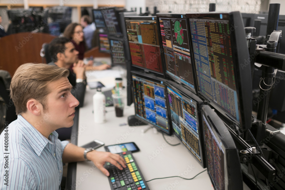 Young traders analyzing computer data Young traders analyzing computer data