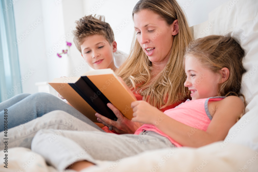 Mother reading with daughter (6-7) and son (8-9) Mother reading with daughter (6-7) and son (8-9)