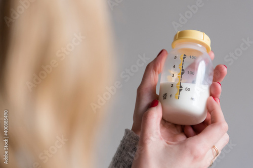 Woman holding baby bottle with milk
