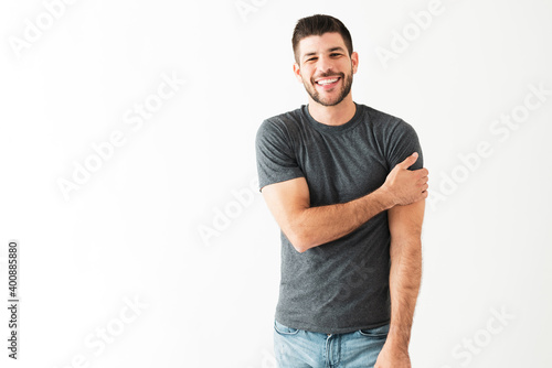 Happy young man smiling and looking shy in front of the camera © AntonioDiaz