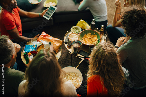 High angle view of sports fans watching TV together at night
