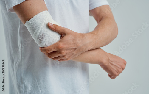 man with bandaged arm elbow and finger injury medicine