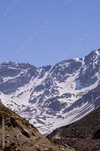Snowy road between the mountains of Cajon del Maipo, Road to El Yeso Reservoir vertical