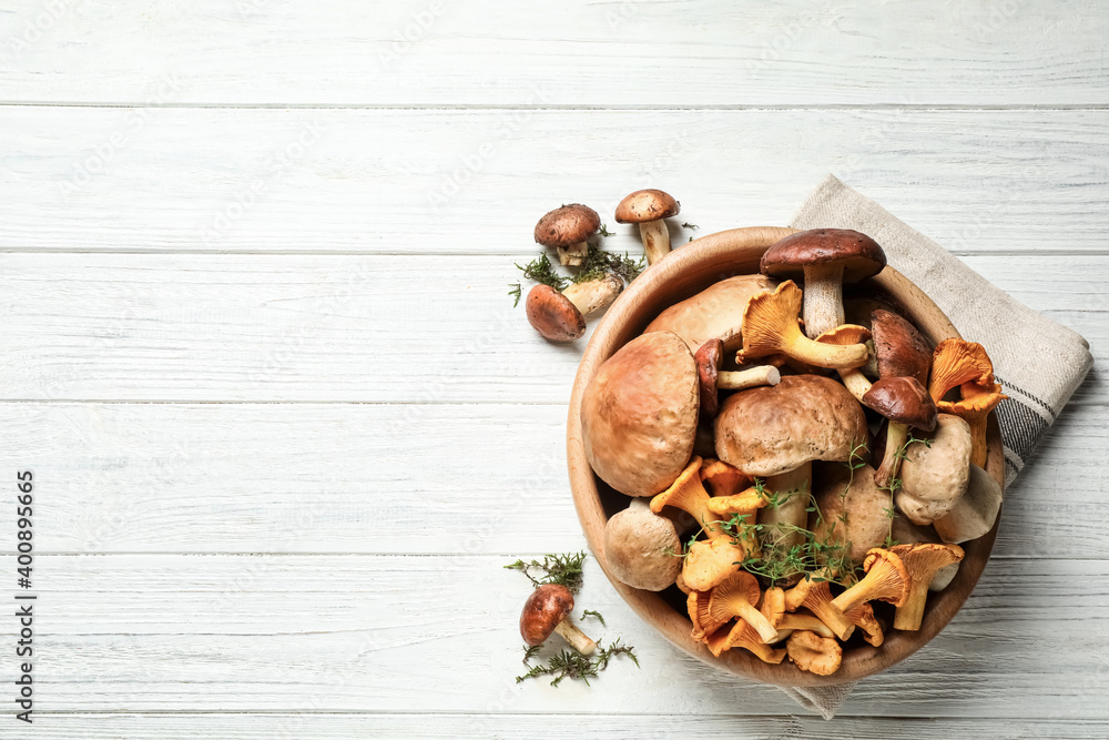 Different fresh wild mushrooms on white wooden table, flat lay. Space for text Different fresh wild mushrooms on white wooden table, flat lay. Space for text