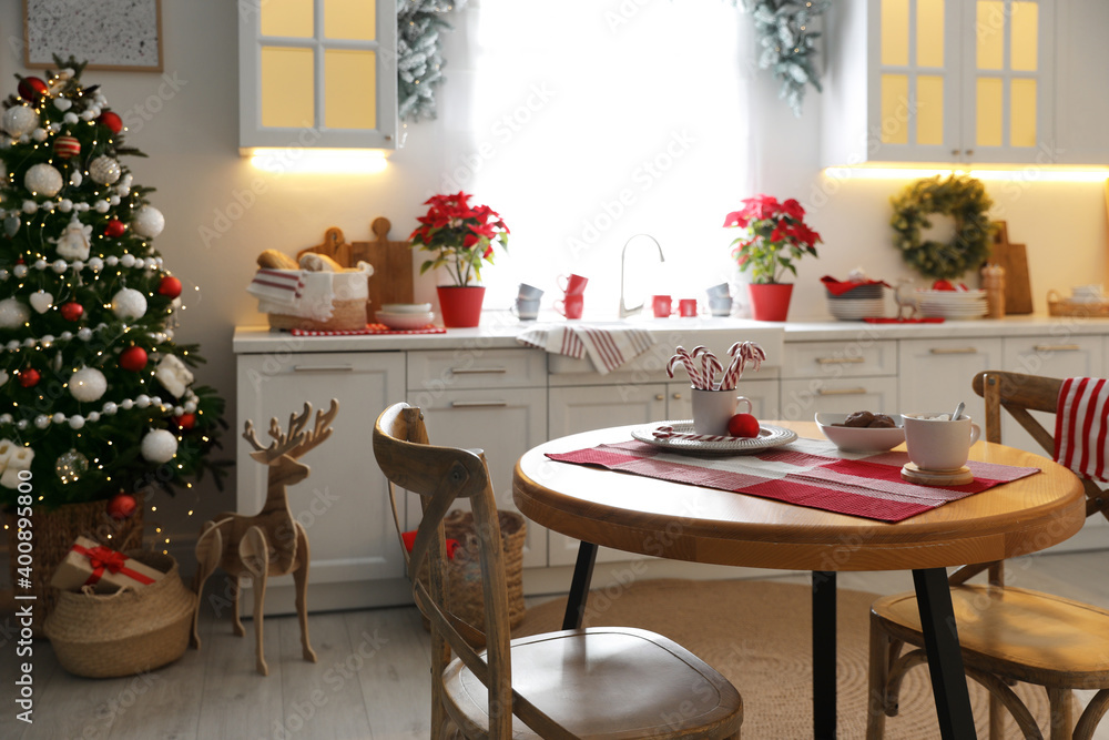Obraz premium Beautiful kitchen interior with Christmas tree and festive decor