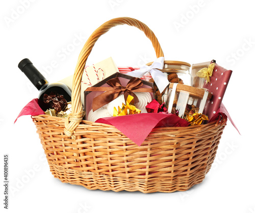 Wicker basket full of gifts isolated on white photo