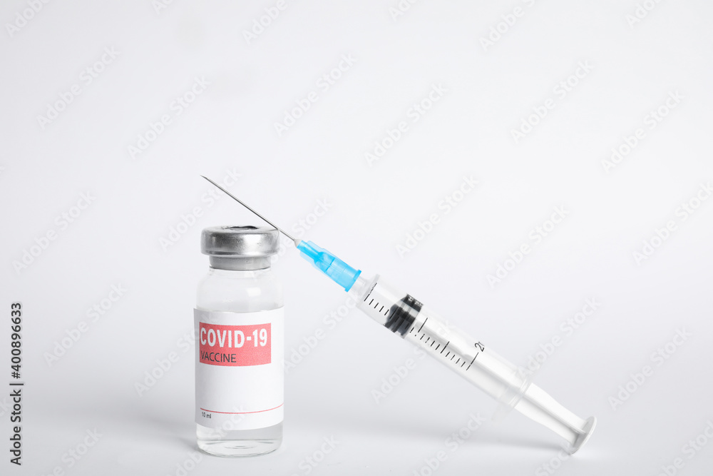 Vial with coronavirus vaccine and syringe on white background