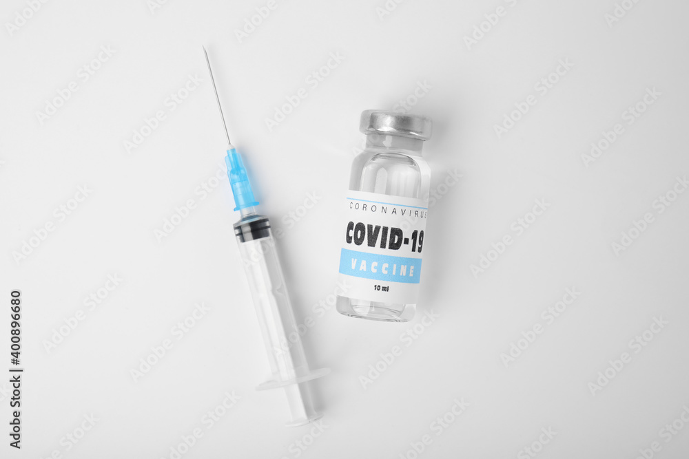 Vial with coronavirus vaccine and syringe on white background, flat lay Vial with coronavirus vaccine and syringe on white background, flat lay