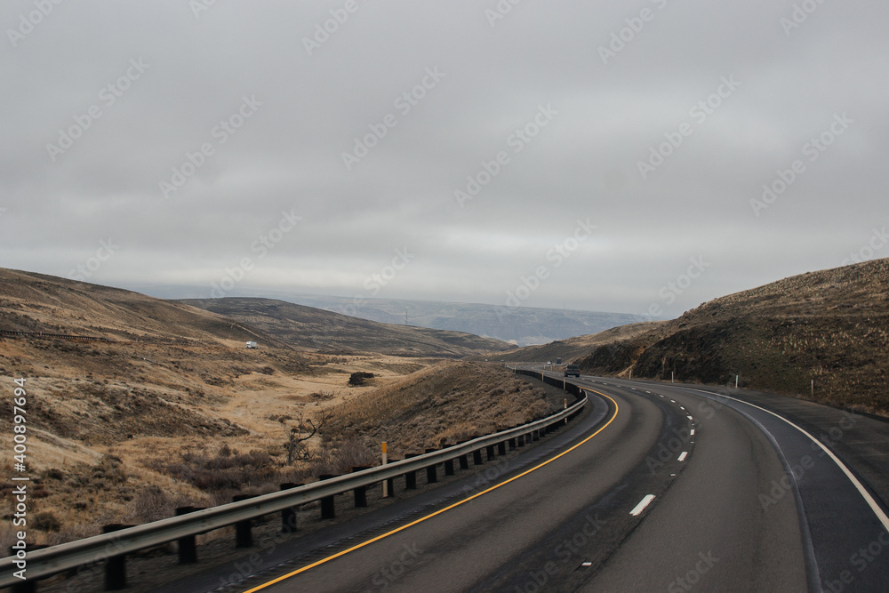 Autumn highway with trucks and cars among the mountains, bridge, road signs on a cloudy day. Oregon, USA, 02-07-2020