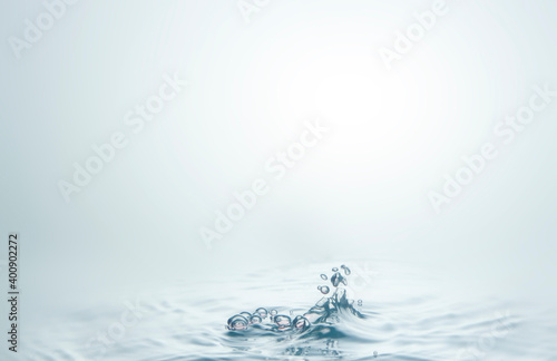 Many water droplets are both sharp and blurry. Falling on the water surface light blue, creating waves on the water surface