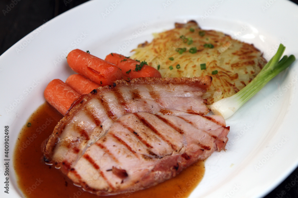 Roasted honey ham with potato cake , carrots and gravy