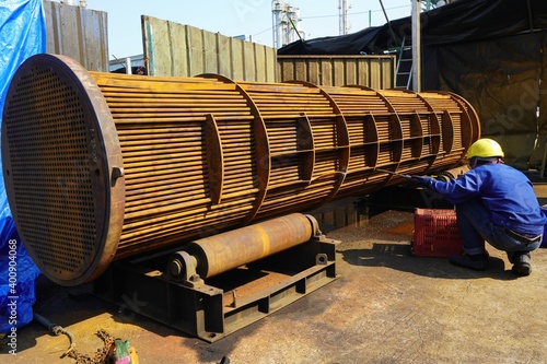 Heat exchanger in the tube bundle sheet corrosion product with workers inspecting for cleaning.