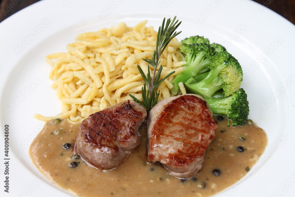 Pork medallions with broccoli and Spätzle on green pepper sauce Pork medallions with broccoli and Spätzle on green pepper sauce