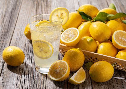 Lemons and lemon sours in a basket set against a wooden background photo