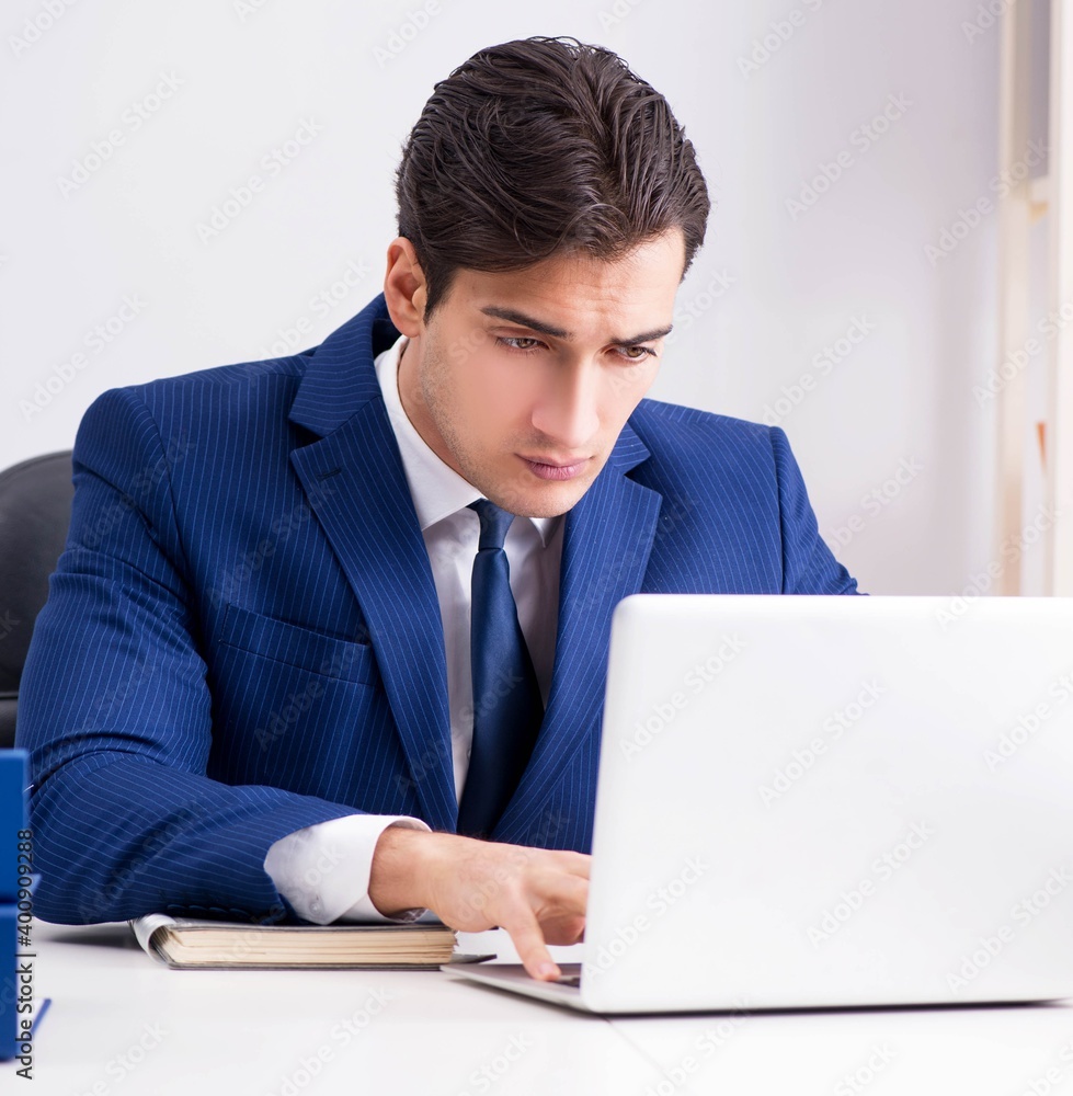 Young handsome businessman employee working in office at desk Young handsome businessman employee working in office at desk