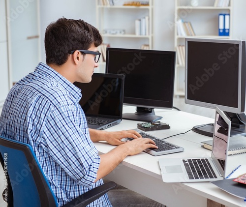 Businessman sitting in front of many screens