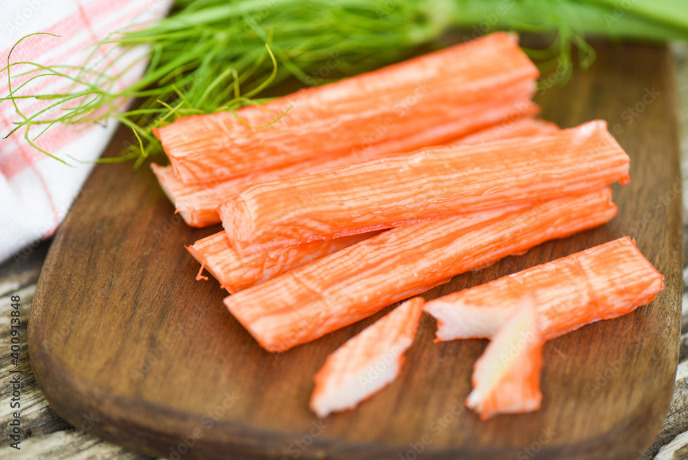 Crab sticks on wooden cutting board and vegetable , Fresh crab sticks surimi ready to eat japanese food.