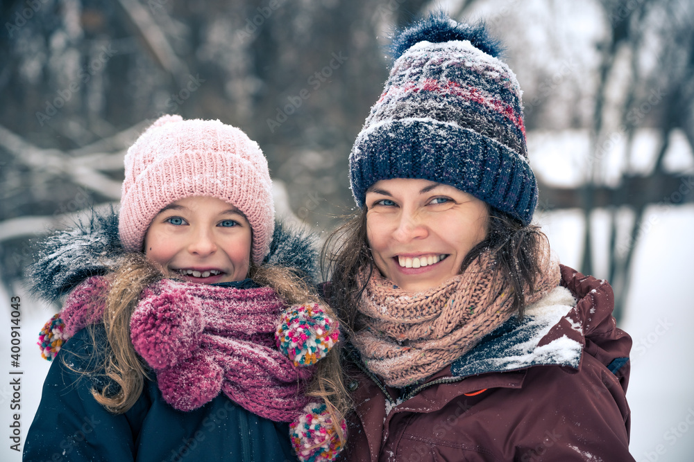 Little girl and her mother playing outdoors at winter day. Active winter holydays concept. Little girl and her mother playing outdoors at winter day. Active winter holydays concept.