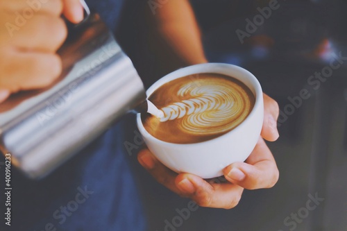 Close up barista hands making latte art.