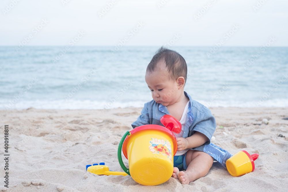 Adorable Cute Asian baby boy playing with beach toys on tropical beach Adorable Cute Asian baby boy playing with beach toys on tropical beach