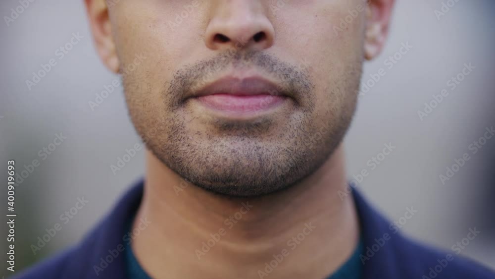Camera tilts up to reveal handsome Asian man looking to camera with no expression Camera tilts up to reveal handsome Asian man looking to camera with no expression