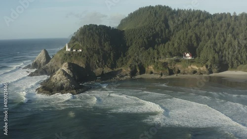 Wide tracking aerial toward Haceta Head lighthouse in Oregon photo