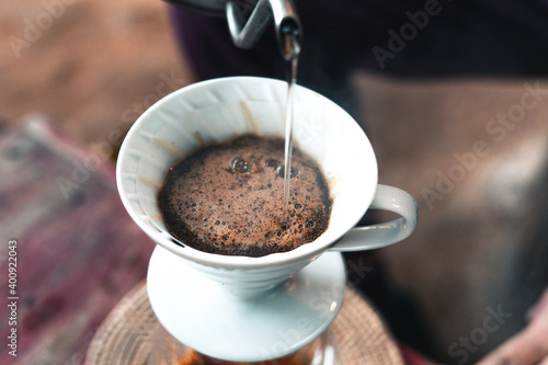 Drip coffee, barista pouring water on coffee ground with filter