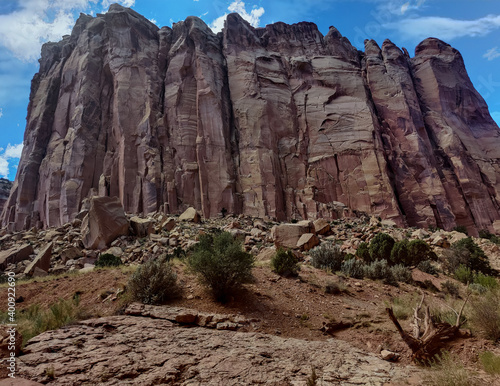 Unbelievable sandstone cliff and superlative domes with tumbleweeds on a hot summer partly cloudy day in Capitol Reef National Park in Southern Utah