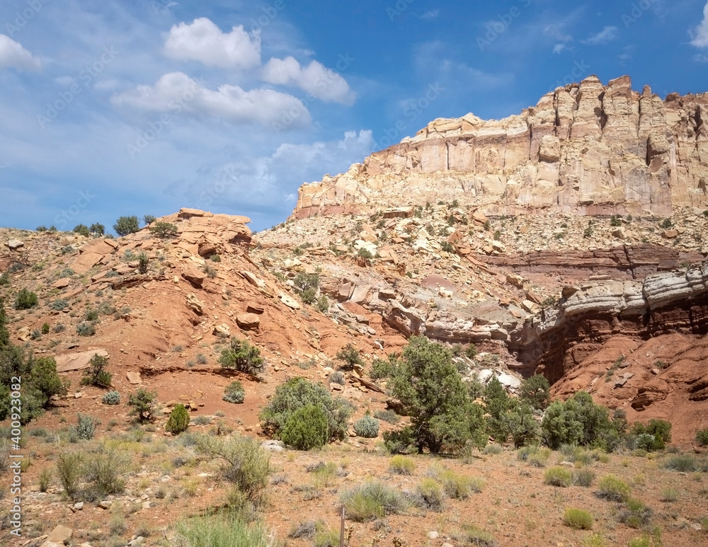 Unbelievable sandstone cliff and superlative domes with tumbleweeds on a hot summer partly cloudy day in Capitol Reef National Park in Southern Utah Unbelievable sandstone cliff and superlative domes with tumbleweeds on a hot summer partly cloudy day in Capitol Reef National Park in Southern Utah