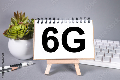 6G, text on white notepad paper on gray background 6G network connection concept