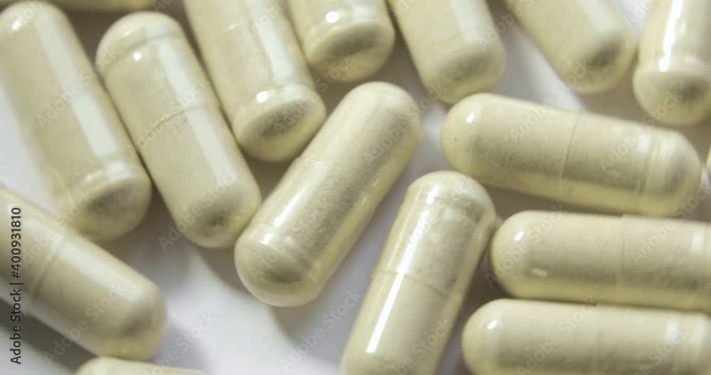 Medication beige pills are rotating on white background, closeup view. Vitamins, dietary supplements, antibiotic, drugs for people. oncept of medicines and medical preparations. Medication beige pills are rotating on white background, closeup view. Vitamins, dietary supplements, antibiotic, drugs for people. oncept of medicines and medical preparations.